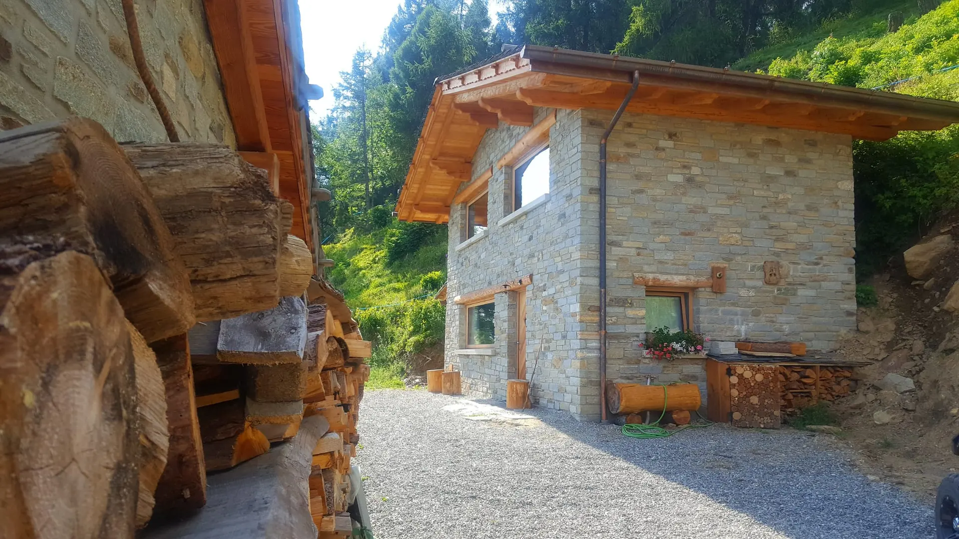 La Baita Belotti in pietra e legno tra i larici, d'estate