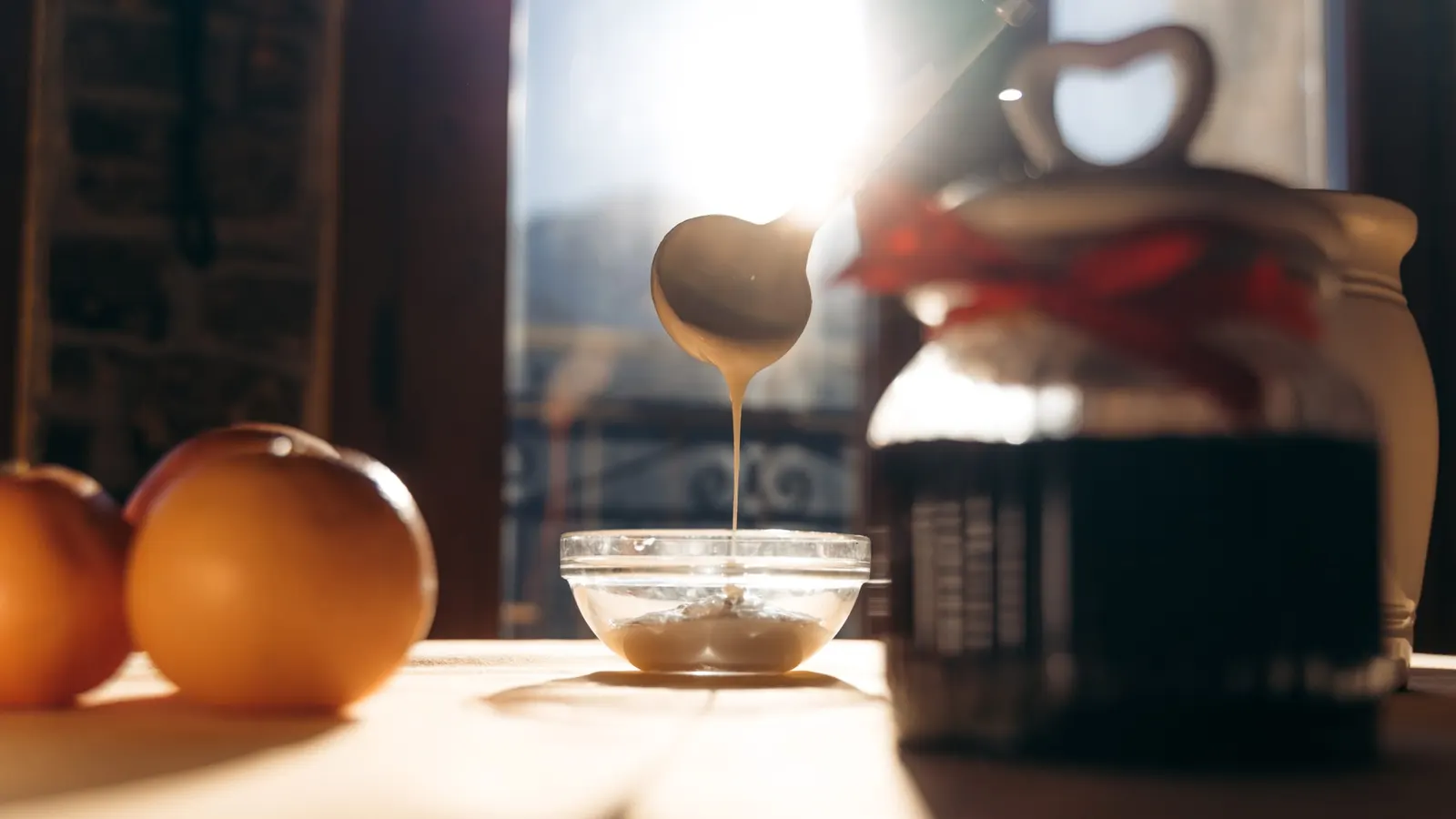 Miele versato da un cucchiaio a forma di cuore, a colazione Miele versato da un cucchiaio a forma di cuore, a colazione