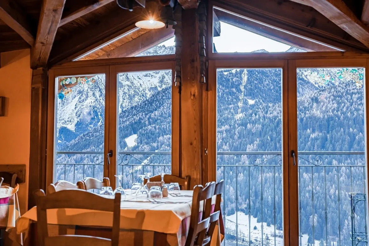 La sala del ristorante con le vetrate sulle montagne innevate La sala del ristorante con le vetrate sulle montagne innevate