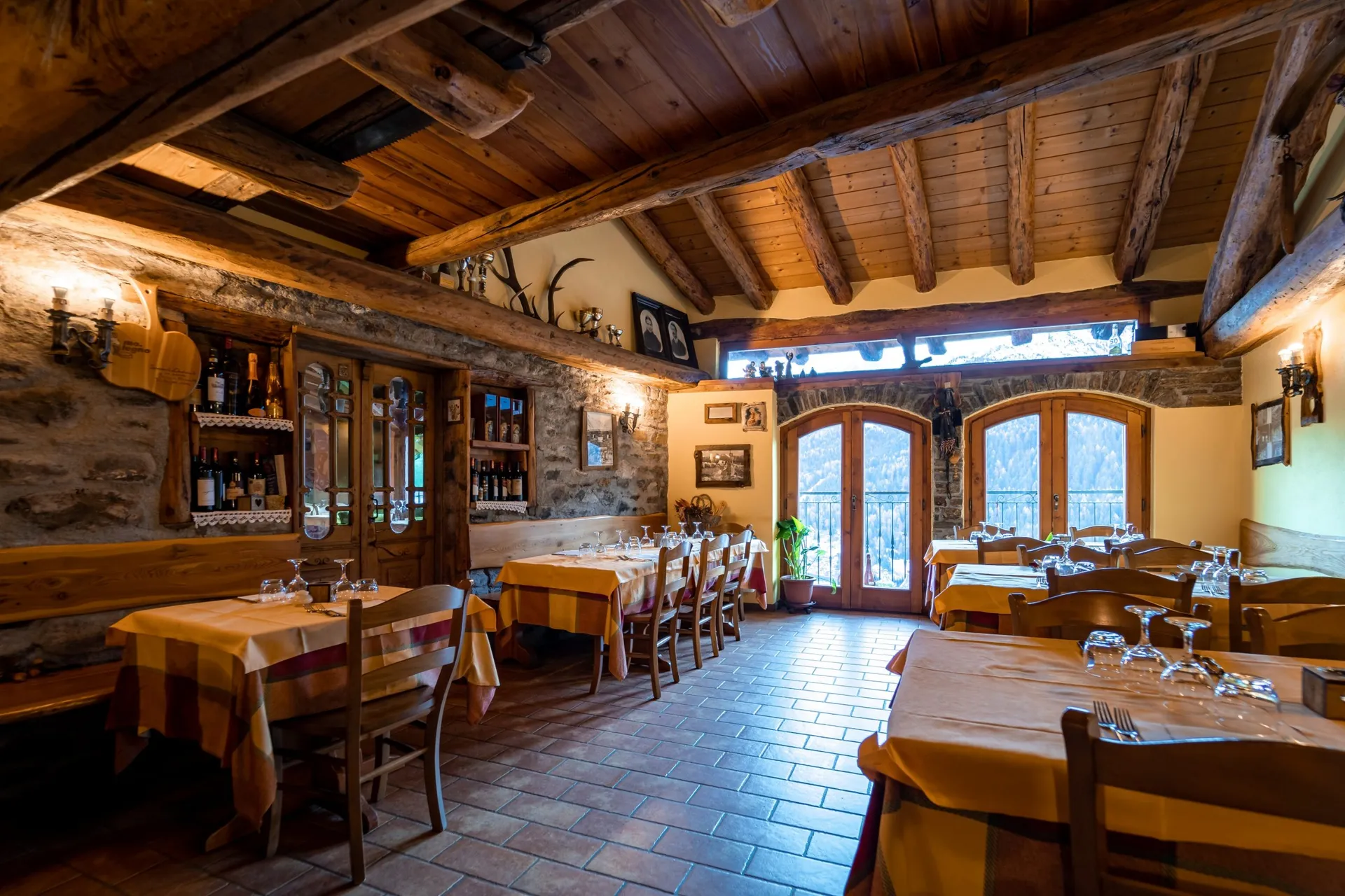 La sala da pranzo La sala da pranzo dell'Agriturismo Belotti con travi in legno e finestre sulla valle