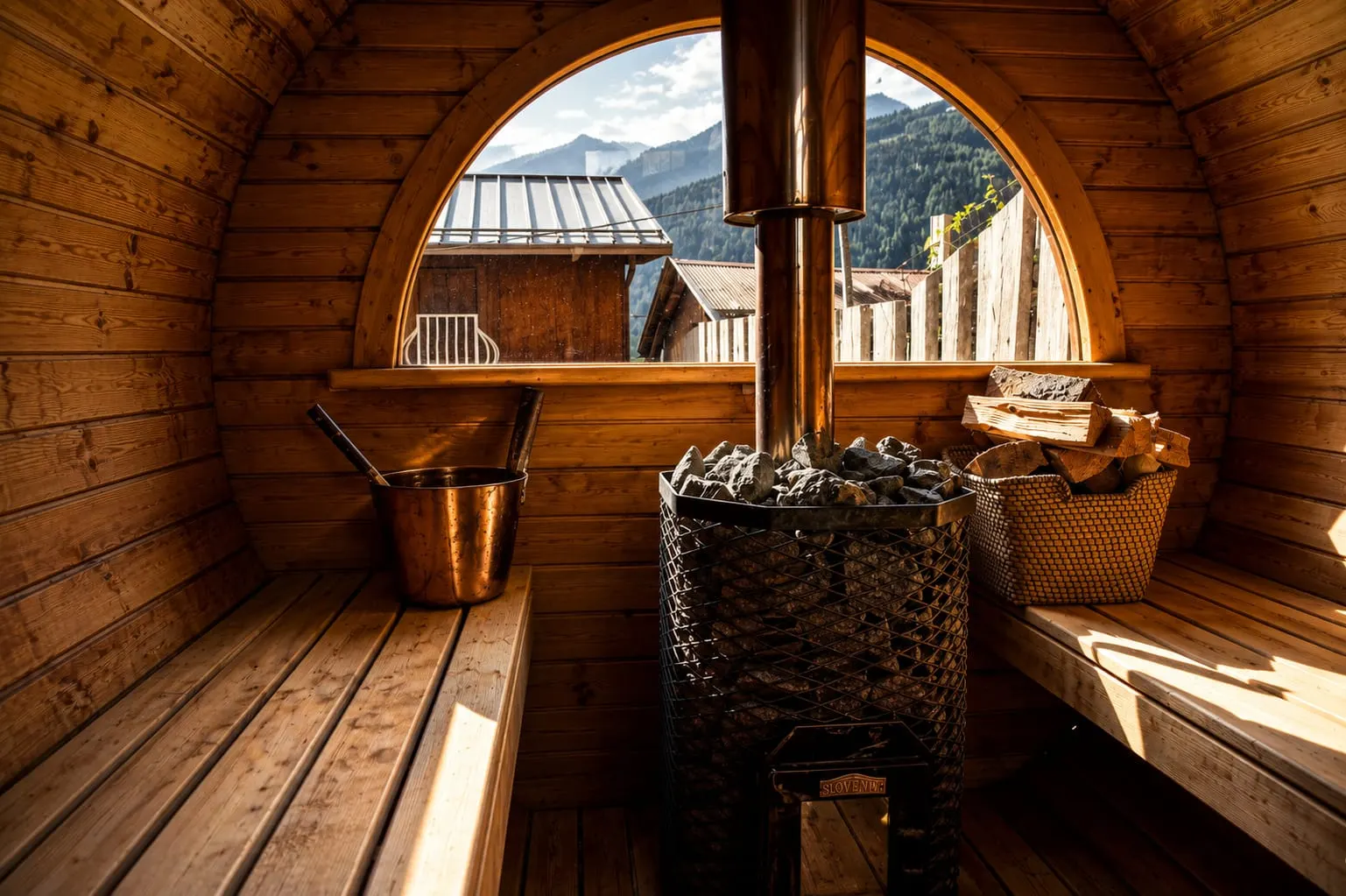 Dentro la sauna a botte L'interno in legno della sauna a botte, con la finestra tonda sulle montagne