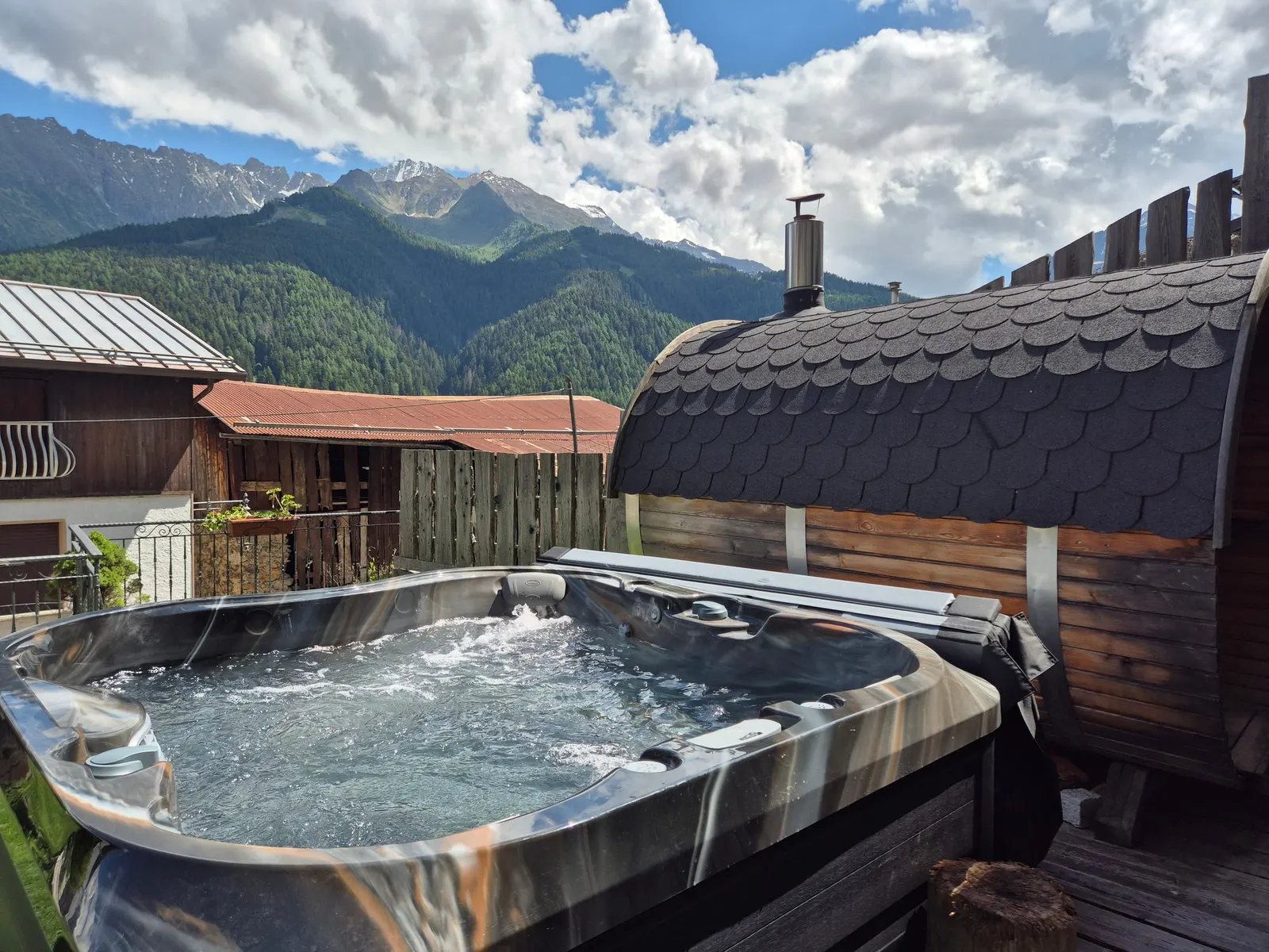 Jacuzzi e sauna a botte in giardino La jacuzzi e la sauna a botte nel giardino dell'Agriturismo Belotti, con le montagne sullo sfondo